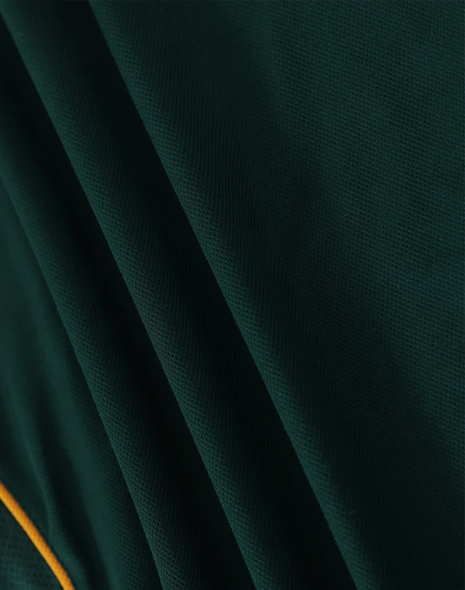 A green polo shirt with textured fabric and contrasting yellow detailing, featuring a logo.