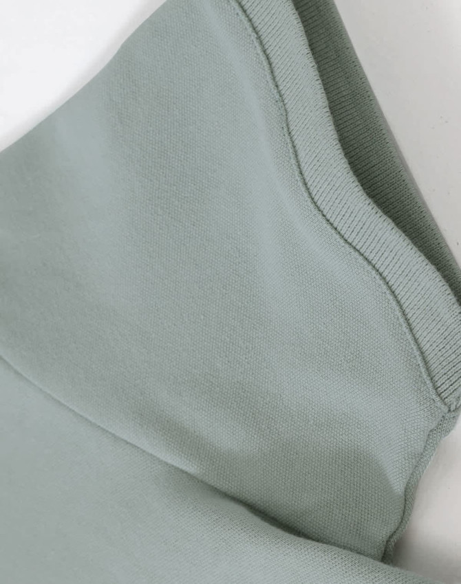 A close-up of a light green ladies cotton stretch polo, highlighting the fabric and collar details.