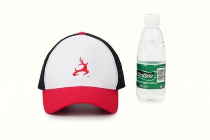 A red and black cap with a logo, positioned next to a clear drink bottle.