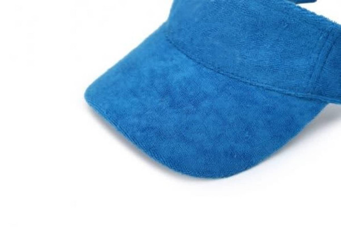 A bright blue soft peak visor with a textured finish, featuring a curved brim and an adjustable strap.