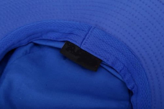 A blue wide brim hat featuring a textured design and a tag inside. It has a spacious, comfortable interior.