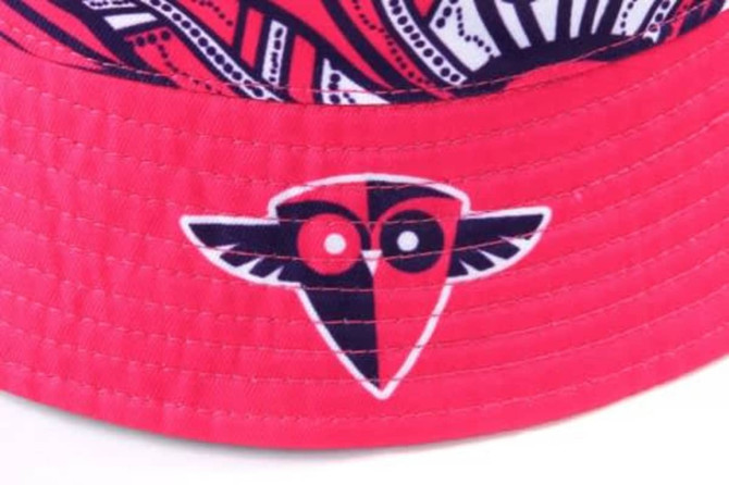A reversible bucket hat in vibrant pink with a patterned brim and a logo on the side.