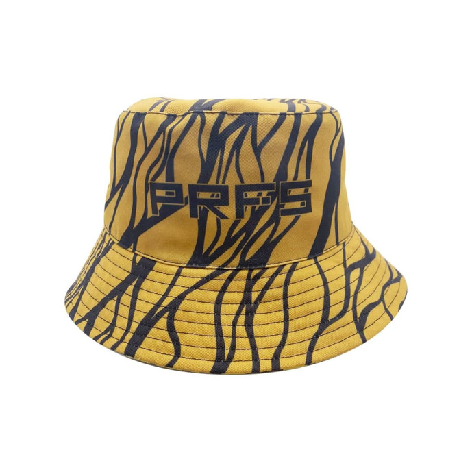 A reversible bucket hat in yellow with black striped patterns and a logo. The design features a wide brim.