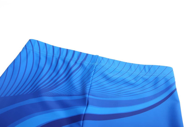 Blue shorts featuring a wave pattern design, with a stretchable waistband and a branding logo.
