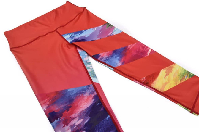 A pair of women's 3/4 pants in vibrant red with multicoloured abstract patterns on the sides and a smooth waistband.