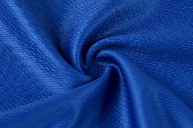 A close-up of textured, vibrant blue fabric, showcasing its smooth and soft material.