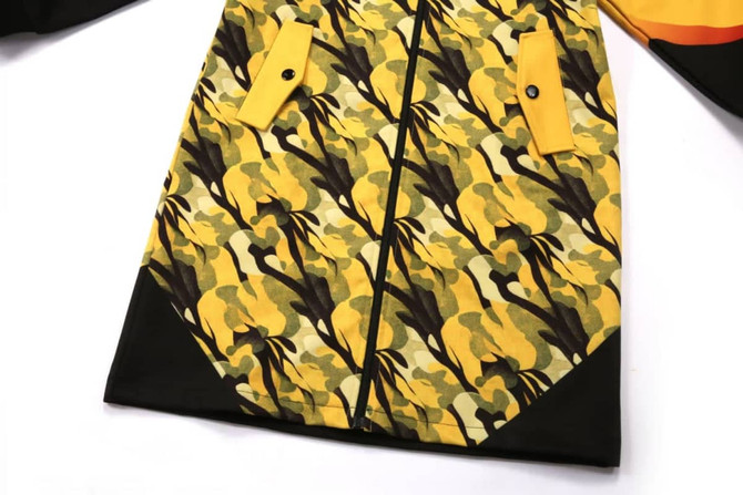 A jacket featuring a yellow and black floral camouflage pattern, with yellow accents and pockets.
