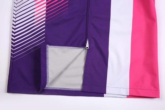 A purple, pink, and white promotional SOFTSHELL DECK COAT with a zippered pocket on the side.