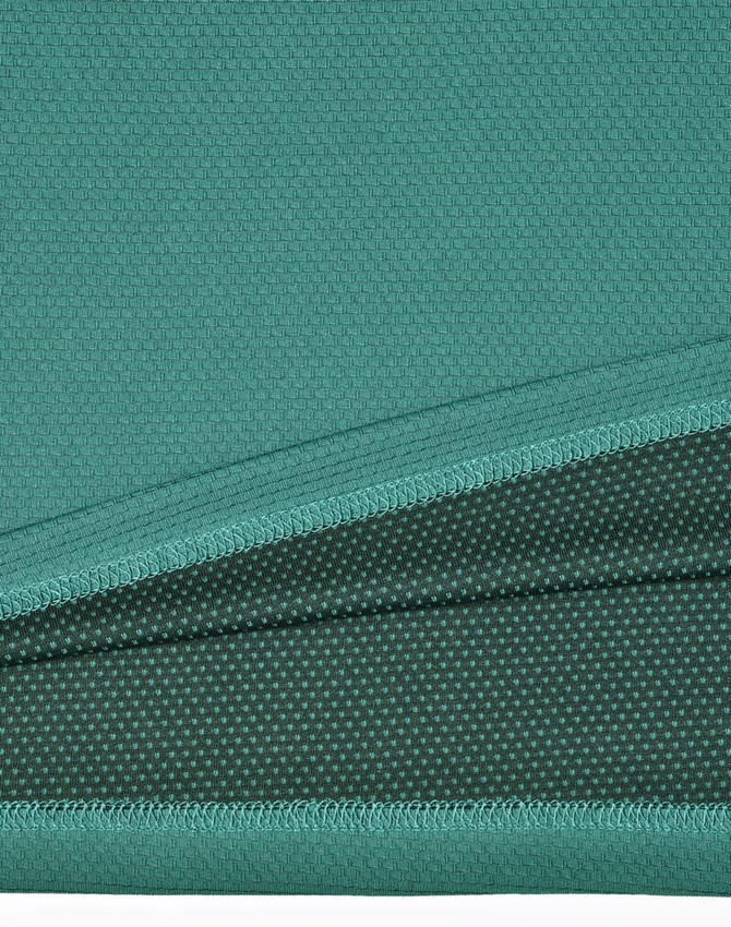 A close-up view of a teal bamboo charcoal polo shirt, showcasing its textured fabric. The shirt features a logo.