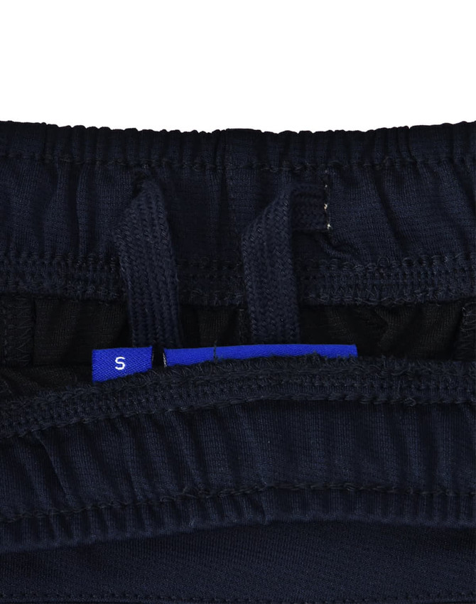 A close-up of navy blue sports shorts, featuring an interior waistband with adjustment tags and a logo.