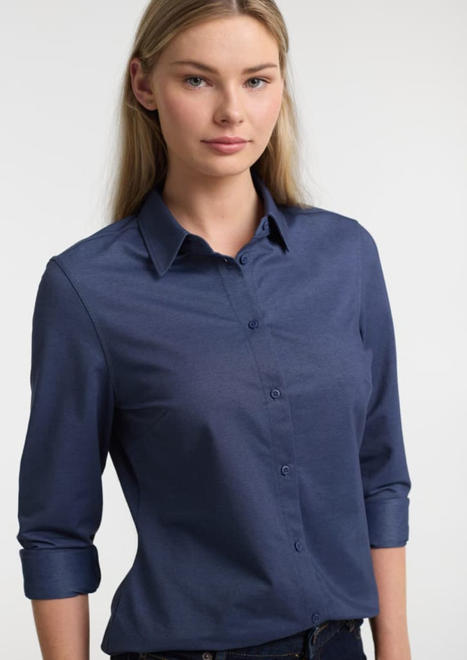 A navy long sleeve shirt for women featuring a button-up front and rolled sleeves, with a logo present.
