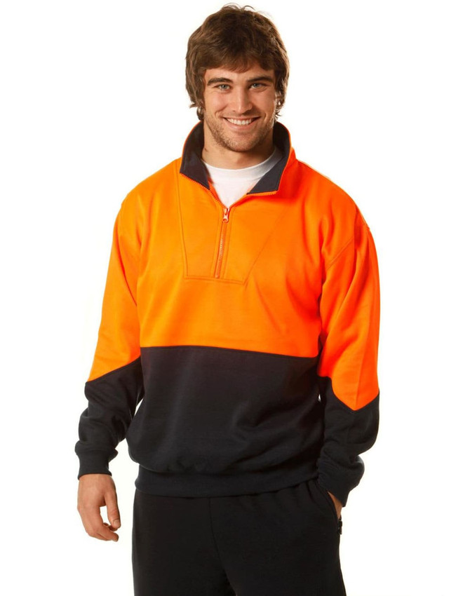 A high-visibility long-sleeve windcheater collar in orange and black, worn by a smiling man. The design includes a zip and a logo.