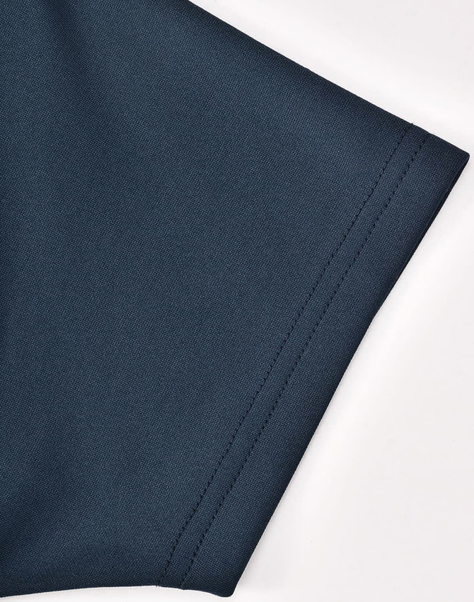 A dark teal polo shirt sleeve featuring sustainable poly/cotton fabric with a smooth texture and a logo.