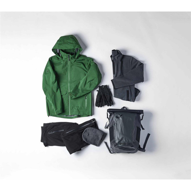 A green waterproof jacket, grey fleeces, black pants, gloves, a beanie, and a grey backpack arranged together.