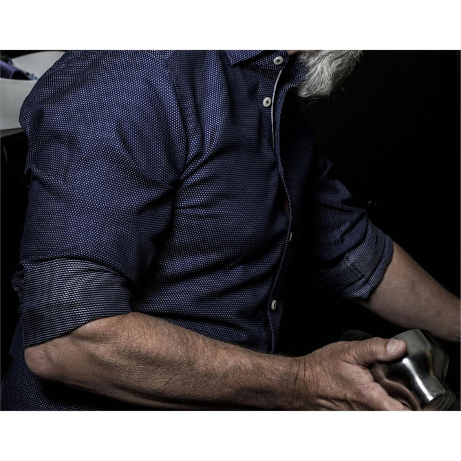 A dark purple button-up shirt featuring a textured pattern and rolled-up sleeves. The shirt has a branding logo.