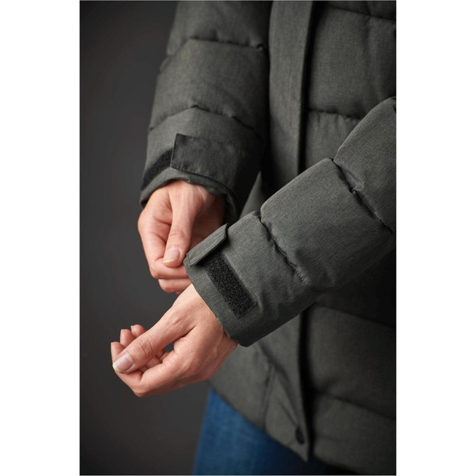 A close-up of a women's green parka jacket, showcasing the cuff detail and texture. The jacket has a logo.