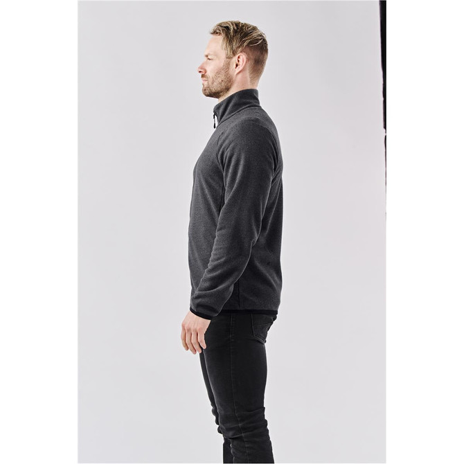 A men's full zip jacket in dark grey, featuring a high collar and a side profile view. It has a logo on the chest.