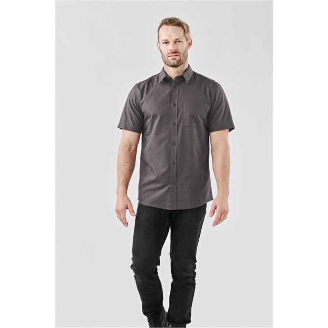 A short-sleeved button-up shirt in grey with a subtle pattern, worn by a male model with a logo present.