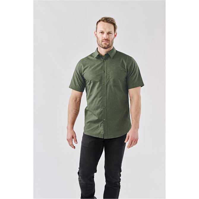 A green short-sleeved button-up shirt on a male model, featuring a subtle texture and a branded logo.