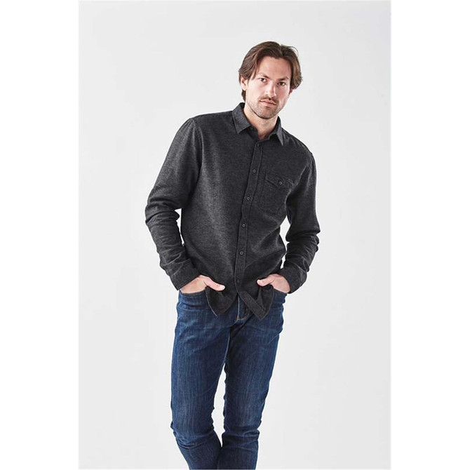 A men's long sleeve twill shirt in dark grey with a button-up front and a chest pocket, worn with blue jeans.