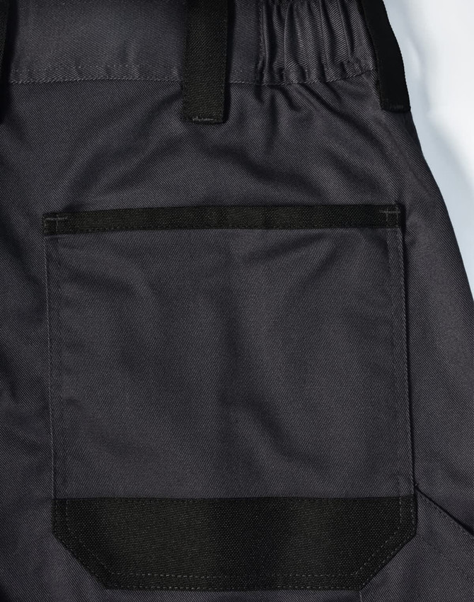 A close-up of black unisex utility stretch cargo work pants featuring a large back pocket and elastic waistband.