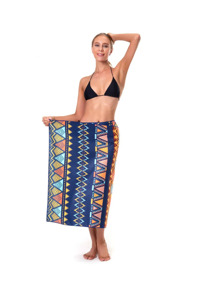A woman in a black bikini holds a vibrant patterned beach towel featuring blue, orange, and yellow colours with geometric designs.