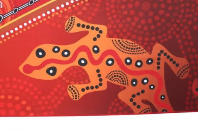 An orange and red beach towel featuring a stylised lizard design with dots and intricate patterns.