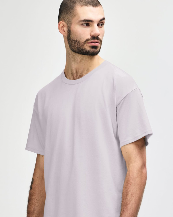 A light grey Gildan Softstyle adult t-shirt with a round neckline displayed on a male model. It features a brand logo.