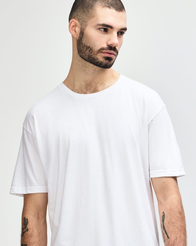 A white Gildan Softstyle adult T-shirt displayed on a model with a neutral background, featuring a logo.