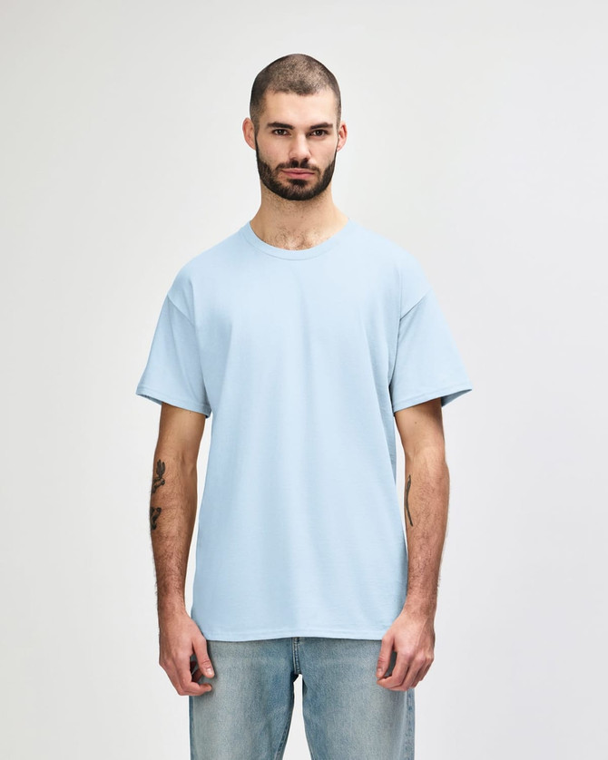 A light blue adult T-shirt displayed on a male model with short sleeves. The shirt features a logo.