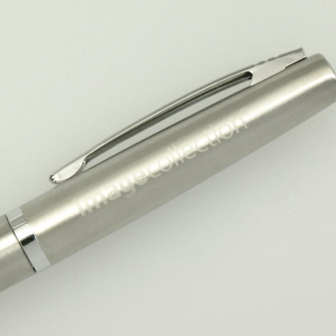 A silver pen with a sleek design and a clip, featuring subtle branding.