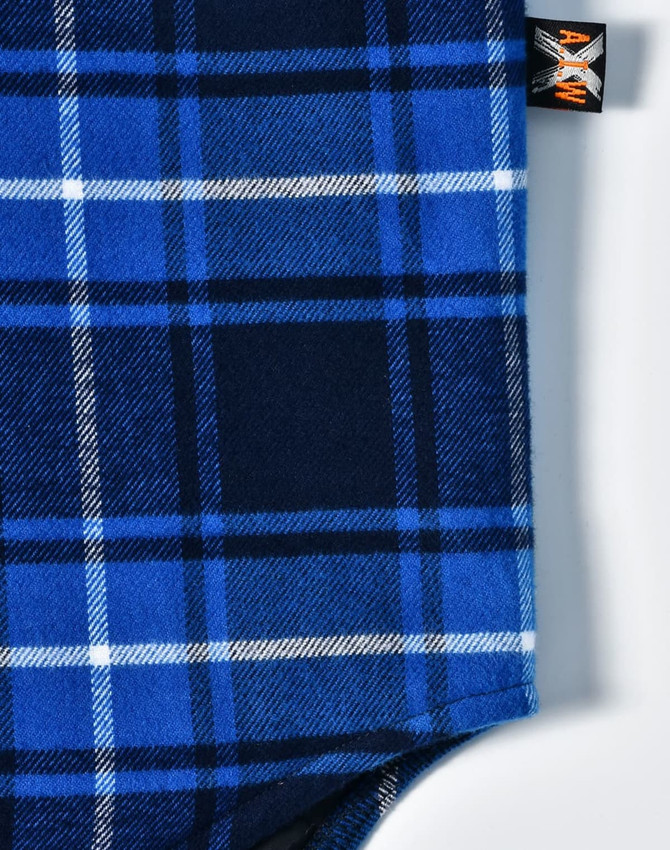 A blue and navy quilted flannel shirt with a checked pattern and a logo tag.