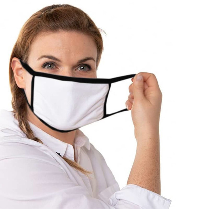 A woman holding a white cotton face mask with black edges. The mask has ear loops for wear.