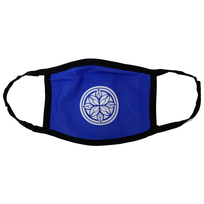A cotton face mask in blue with a black trim and a circular logo design in the centre.