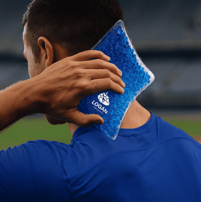 A blue Caviar Bead Cooling Pack held against the neck of a person wearing a blue athletic shirt. The pack has a logo.