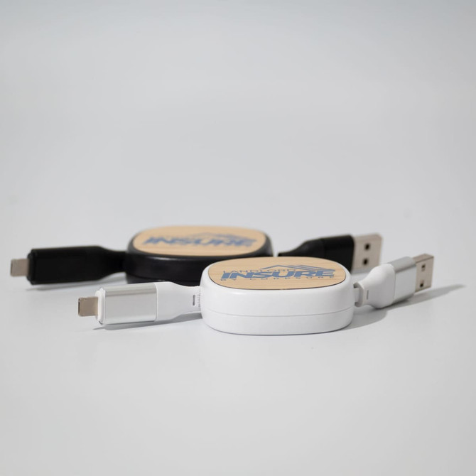 A white and a black retractable charging cable, each with a logo on the circular casing.