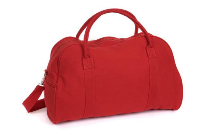 A red duffle bag with handles and a detachable shoulder strap, featuring a logo.