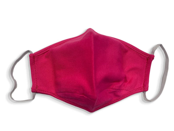 A pink cotton face mask with grey ear straps, featuring a smooth texture and contoured shape.