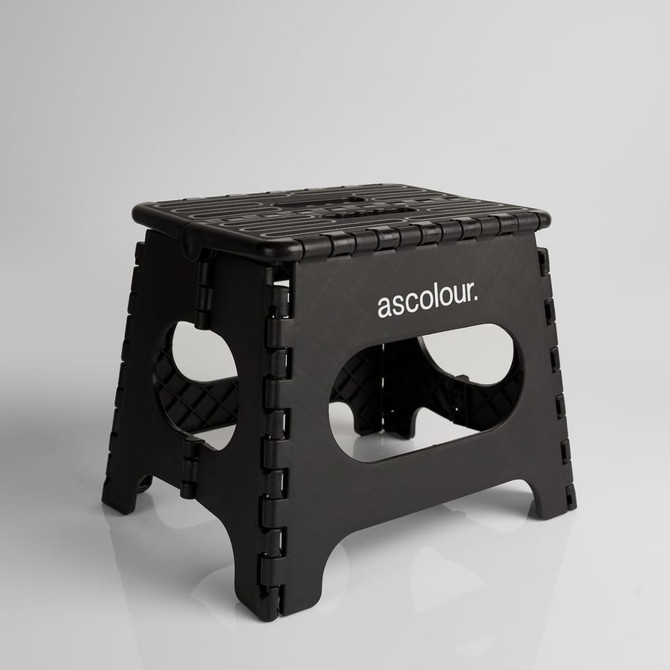 A black ASC Utility Stool with a textured surface and cut-out handles, featuring a logo on one side.