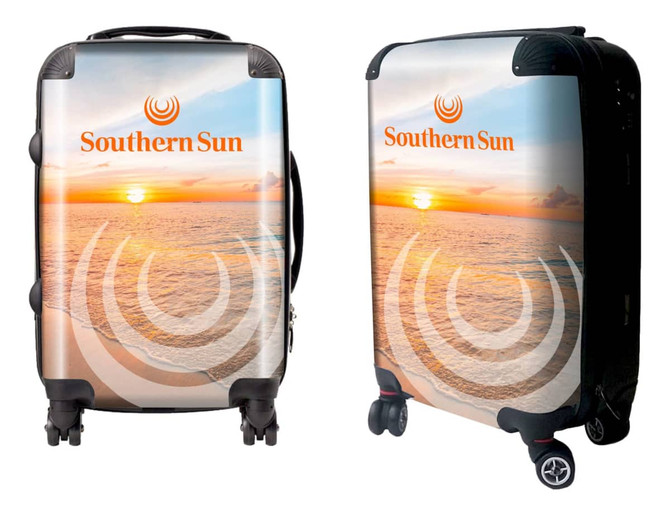 A wheeled suitcase featuring a sunset beach design with a logo. The suitcase has a glossy finish and black wheels.