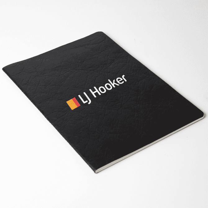 A black Velour DuPont A5 notebook with a textured cover and a logo on the front.