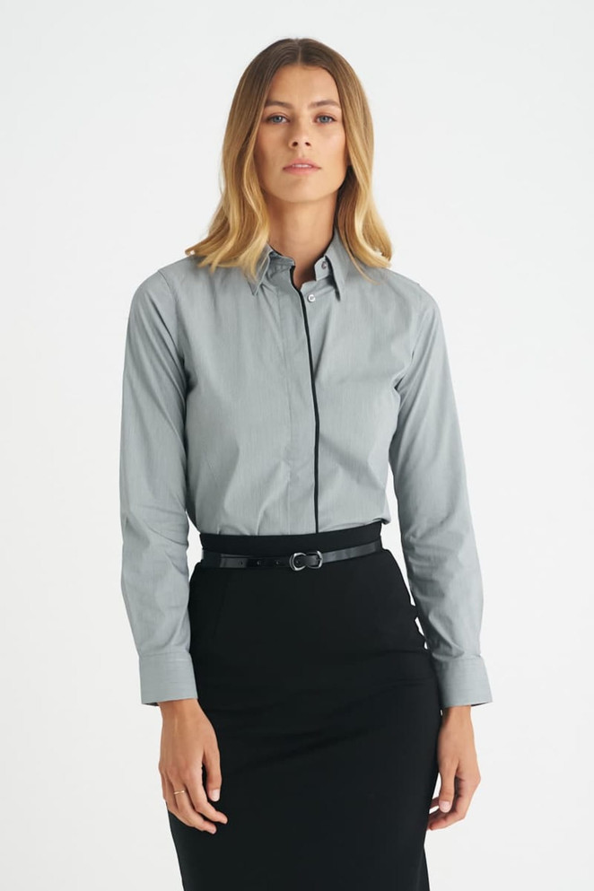 A grey ladies long sleeve button-up shirt worn with a black skirt, featuring a subtle logo.