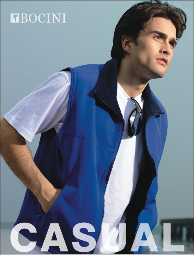 A unisex reversible vest in blue, displayed on a model wearing a white t-shirt and sunglasses, with a logo visible.