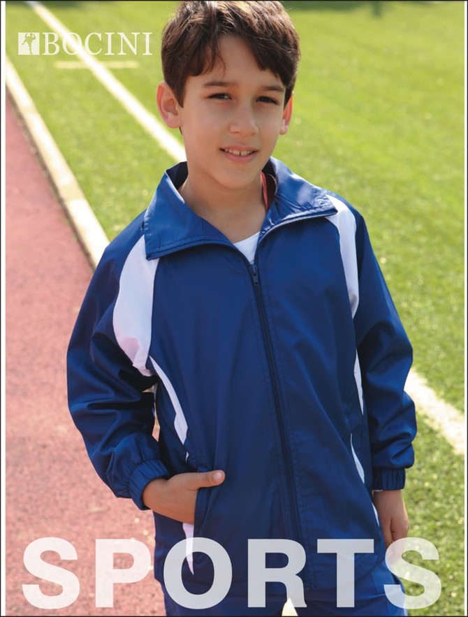 A blue and white kids' track jacket with a logo, worn by a boy standing on an athletic track.