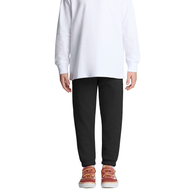 Black track pants for kids, featuring an elastic waistband and cuffs, paired with a white long-sleeve top and casual shoes.