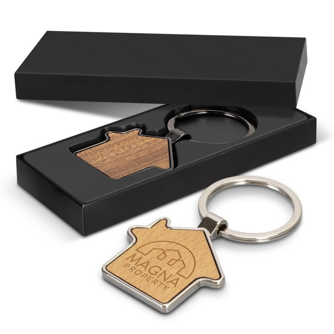 A house-shaped key ring with a wooden centre and a silver metal keyring, presented in a black gift box.