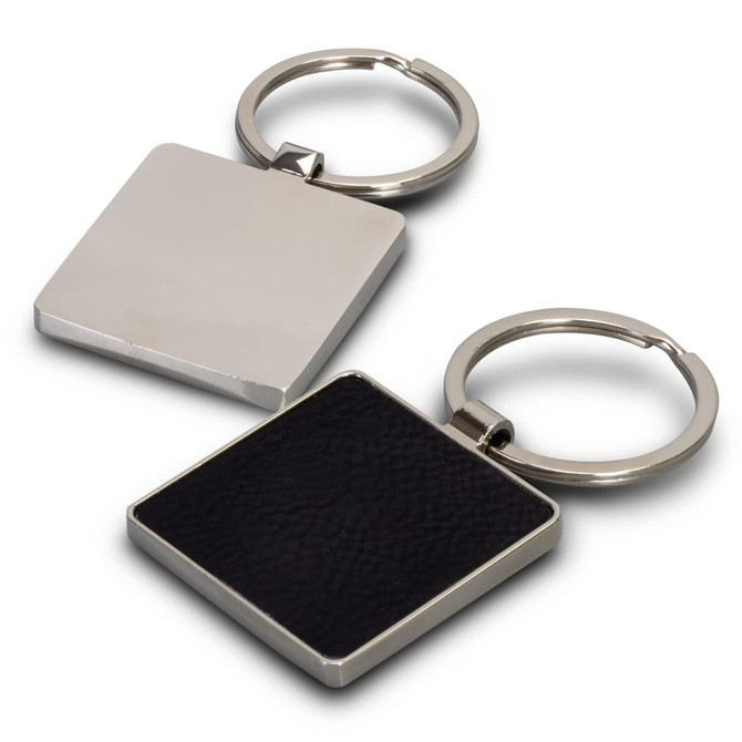 A square key ring featuring a silver metal finish with a textured black surface on one side and a smooth silver back.