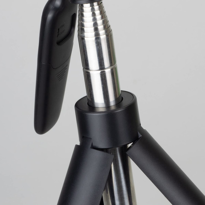 A black tripod with a metallic silver section, featuring a phone holder attachment.