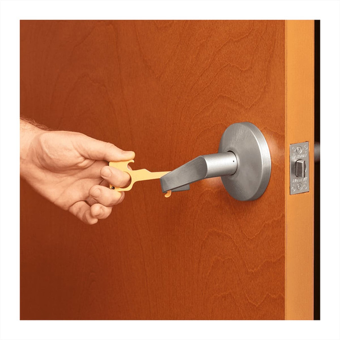A yellow no-contact keychain is being used to open a door handle, featuring a metallic finish.
