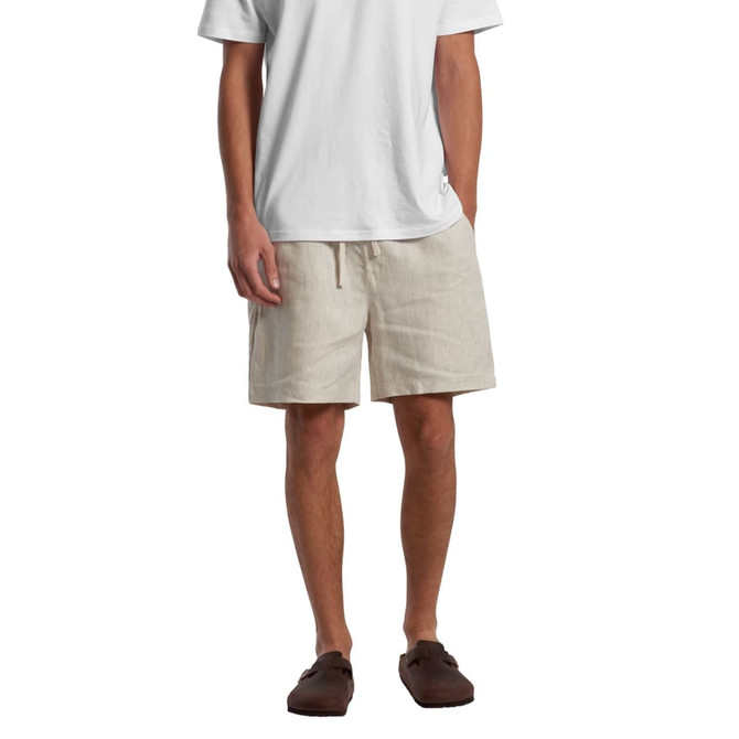 Linen shorts in a light beige colour, featuring a drawstring waist and an accompanying logo.